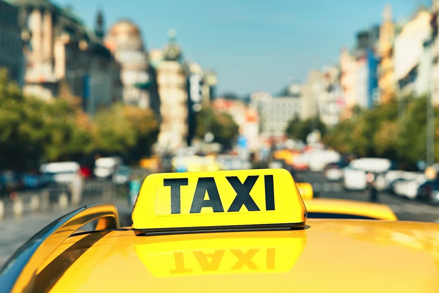 enseigne taxi sur le toit d'une voiture jaune